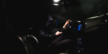 stalker in a car using smartphone