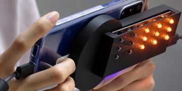 A hand holding a smartphone with SweepLED technology used to detect hidden cameras