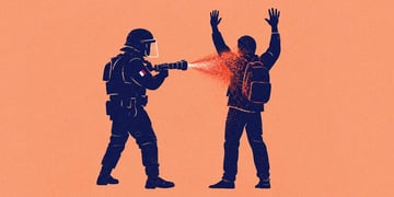 A police office spraying a substance at a protestor