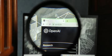 OpenAI logo seen through magnifying glass.