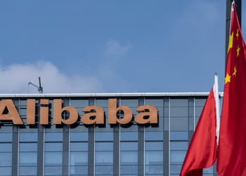 alibaba orange signage atop glass building, blue sky, white cloud, two china's flags