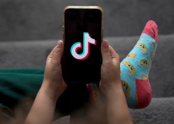 A child holds a smartphone displaying the TikTok logo in an arranged photograph in Sydney, Australia