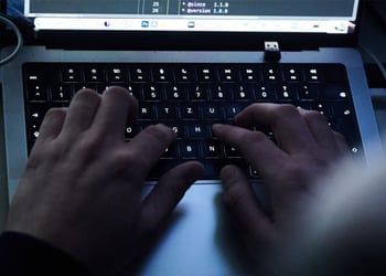 Hands typing on a computer keyboard.