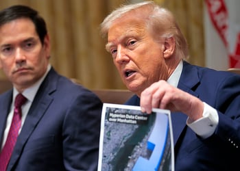 Donald Trump holds up a picture of a data center