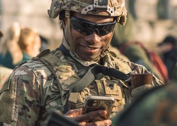 An American soldier holding a smartphone.