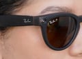 A woman is wearing a pair of Ray-Ban smart glasses.