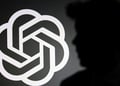 The silhouette of Sam Altman and OpenAI logo