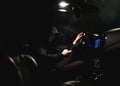stalker in a car using smartphone